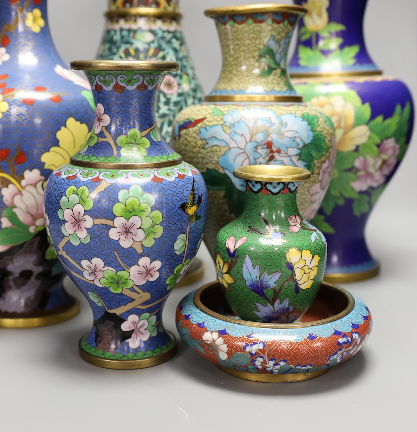 Seven Chinese cloisonné enamel vases and a bowl, tallest 39 cms high